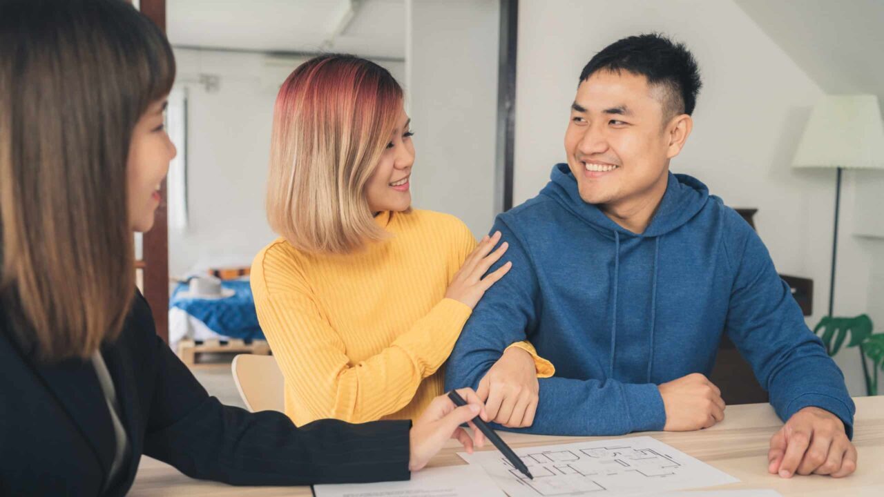 A realtor discusses with home buyers after successfully beating out a cash buyer.